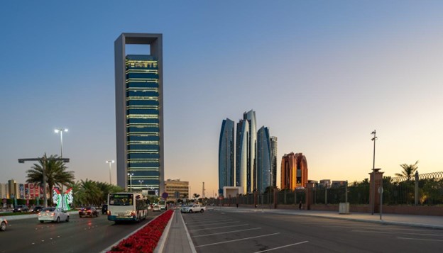 منظر مذهل لأفق مدينة أبو ظبي مع ناطحات السحاب وحركة المرور عند غروب الشمس.