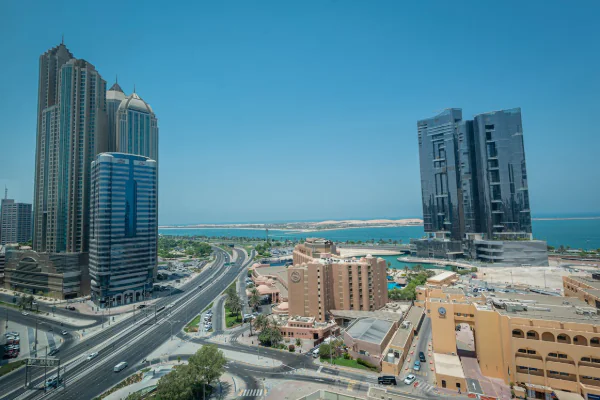 مدينة عصرية بناطحات سحاب وطرق تحت سماء زرقاء