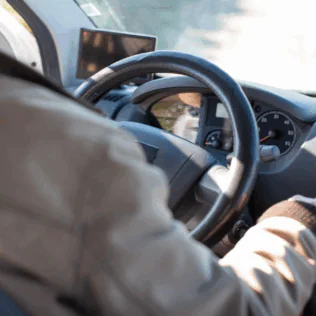 Person in White Long Sleeve Shirt Driving Car