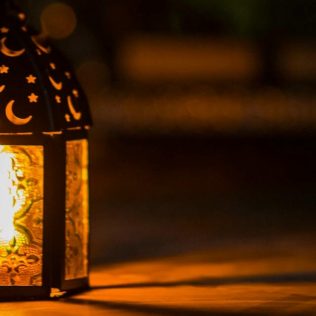 Traditional lantern glowing with warm light during nighttime.