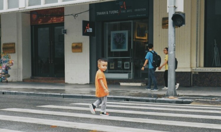 A little boy crossing the road
