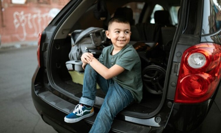 A child sitting in the trunk of a family car