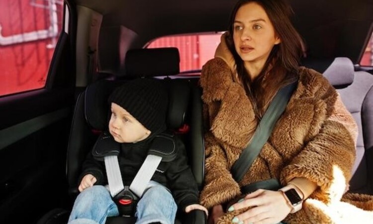 Young mother and child in car Baby seat on chair Safety driving concept