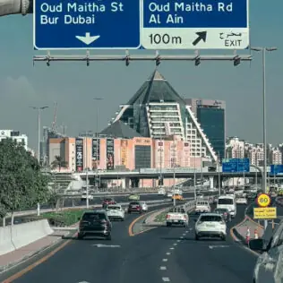 Highway Sign in Dubai with Cityscape View
