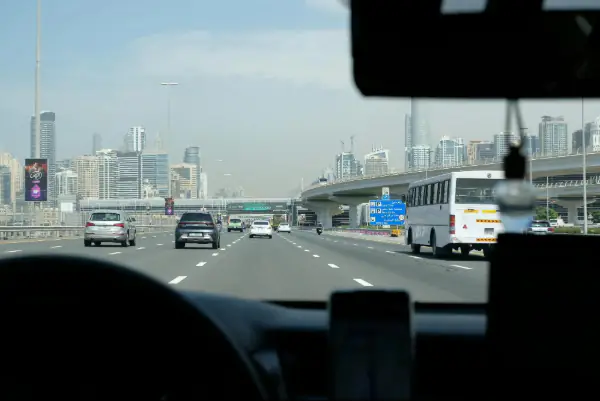 Driving on Dubai highway with a city skyline.