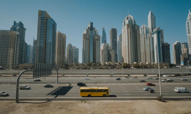 Yellow Bus on Road Near City Buildings in Dubai