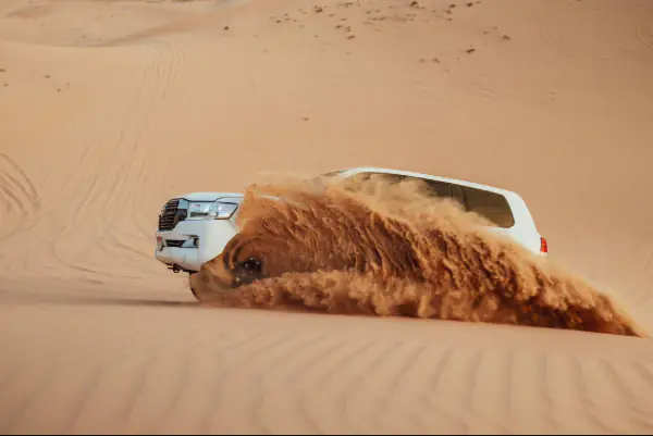 A car kicks up sand in Liwa desert