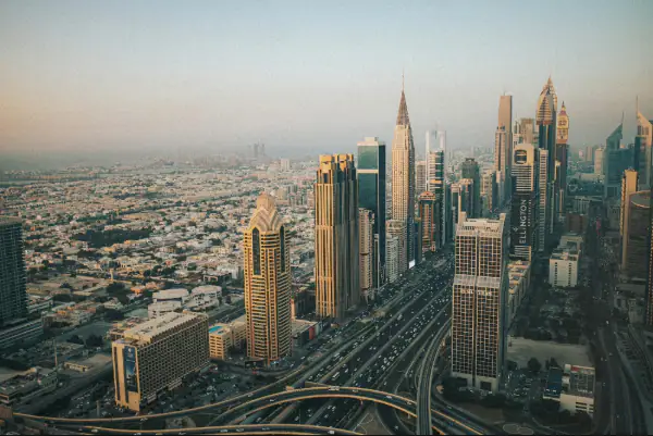 Modern skyscrapers line a busy highway in a sprawling city