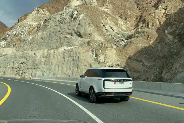 a white car driving down a mountain road to Fujairah